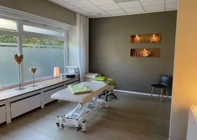 Behandlungsraum mit Liege, Fensterfront und ruhiger Einrichtung